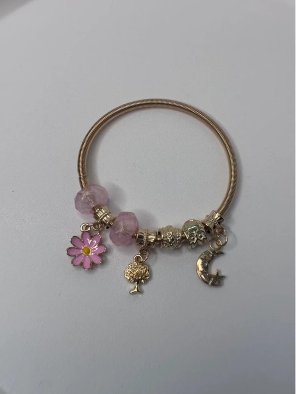 Pink and gold tone charm bracelet